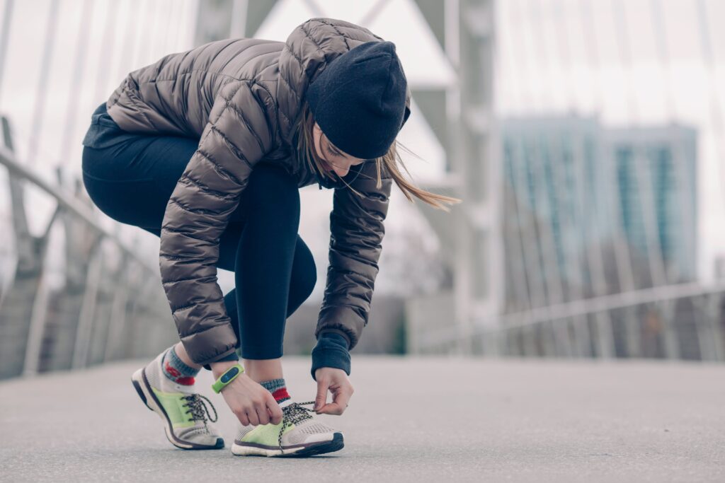 woman-tying-her-running-shoes-in-cold-weather